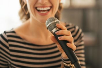 A young woman singing into a dynamic microphone