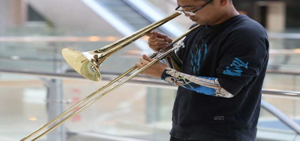 a guy adjusting his trombone