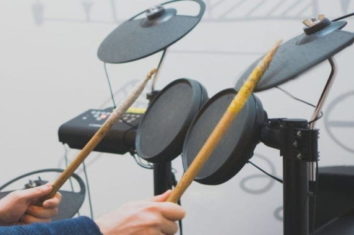 a man playing electric drums with his drumsticks
