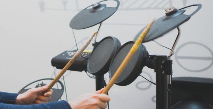 a man playing electric drums with his drumsticks